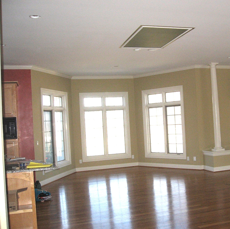 An empty room before anything has been placed in it, with bare windows