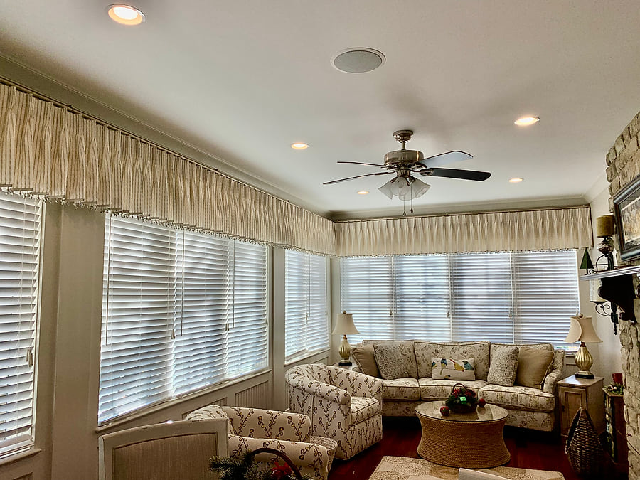 The same sunroom after, refreshed with new paint and valances across the windows