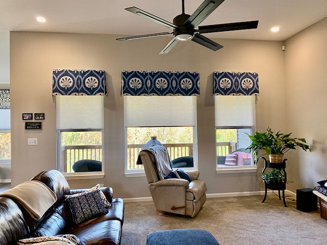 Blue medallion valances above roman shades in a family room
