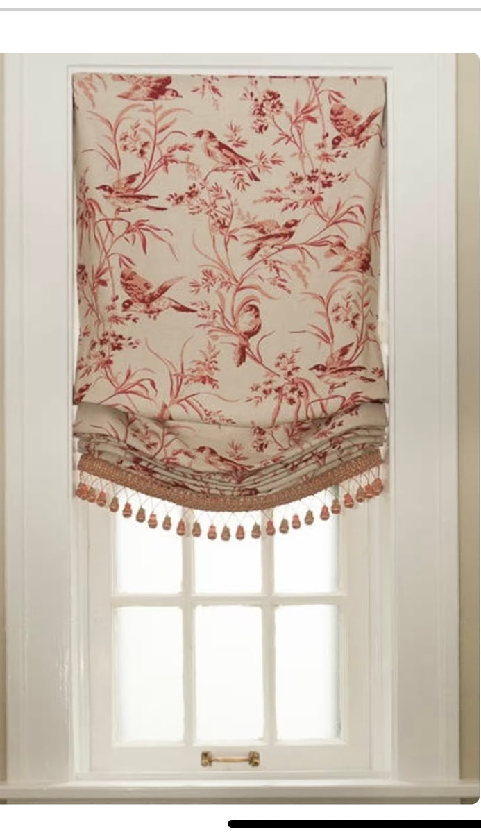 A relaxed roman shade in red toile with a beaded trim